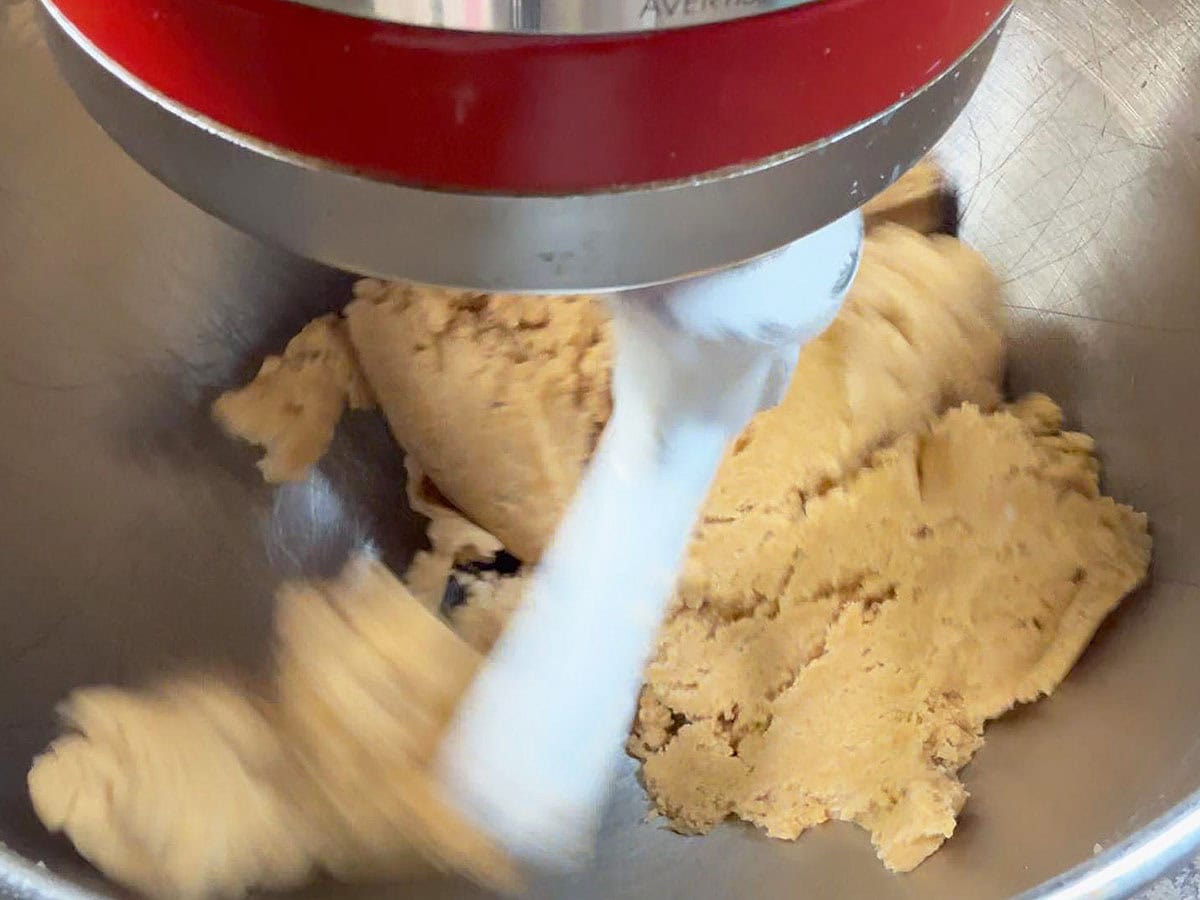 Graham cracker cookie dough coming away from the sides of a mixing bowl.