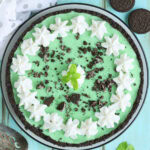 Grasshopper pie garnished with piped whipped cream, crushed cookies, and a mint sprig.