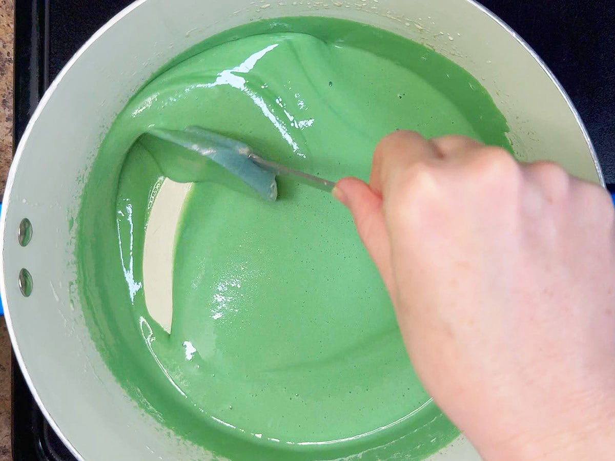 Stirring the creme de menthe, creme de cacao, and green food coloring into the melted marshmallows.