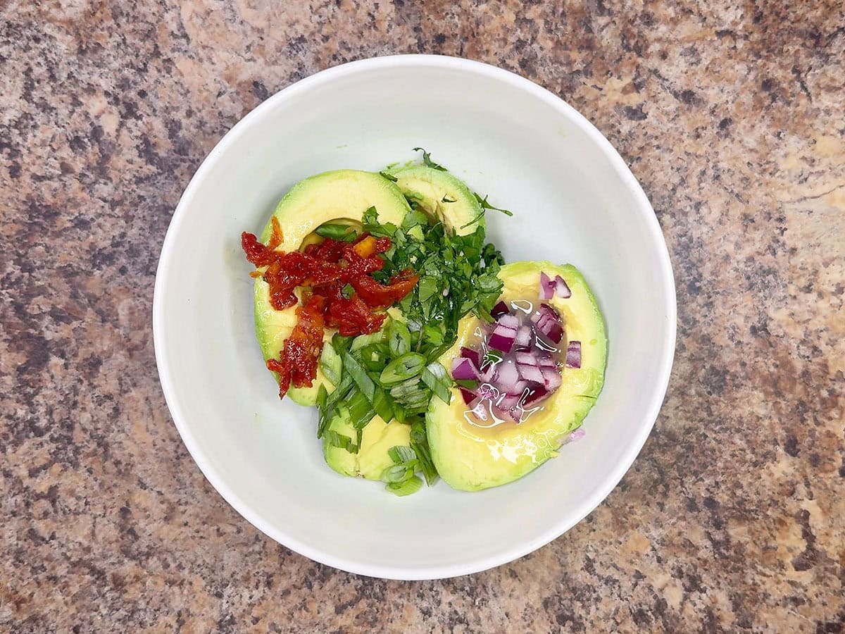Guacamole ingredients measured into a small mixing bowl.