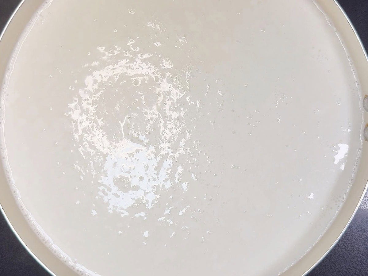 Milk and water coming to a gentle boil.