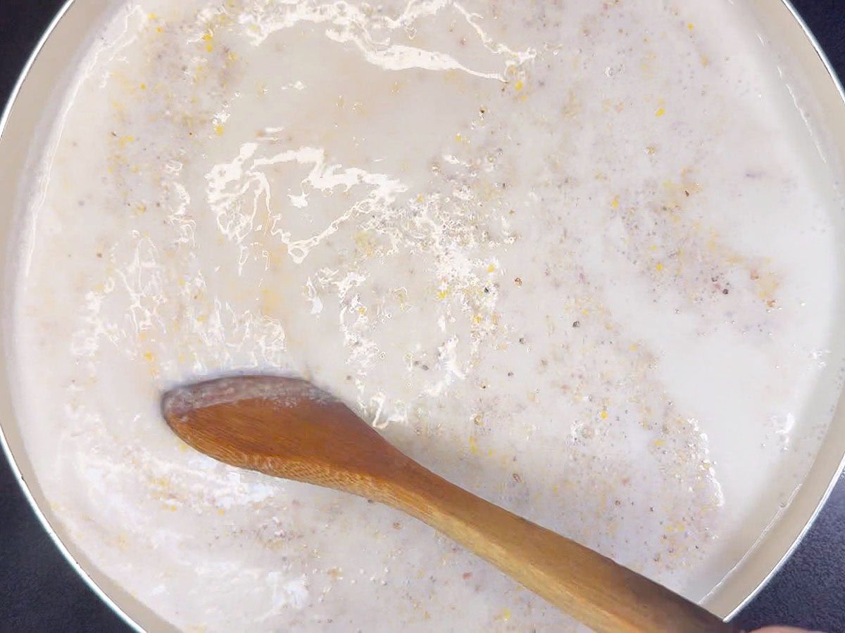 Stirring the grits into the hot milk mixture.
