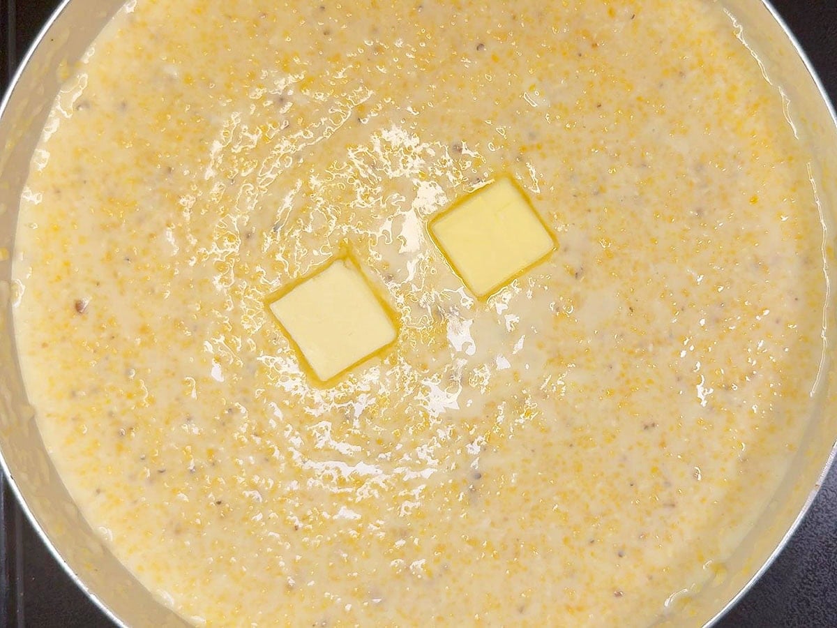 Two tablespoons of butter added to a pan of cheese grits.