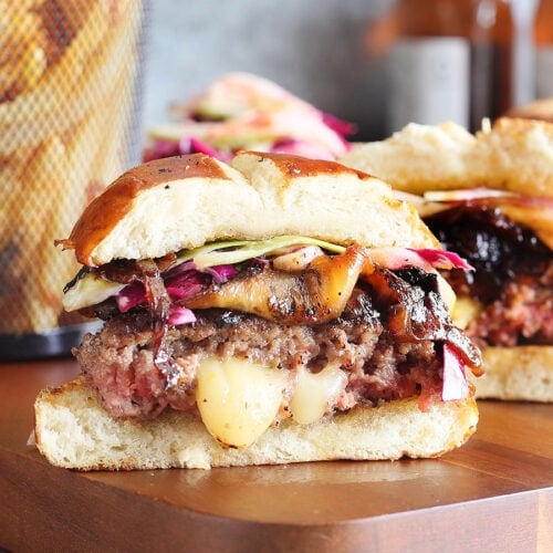 Pepper jack stuffed hamburger sliced in half with melted pepper jack cheese oozing out of the center.