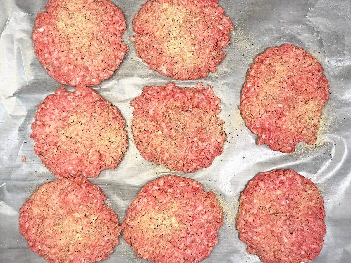 First side of the burger patties seasoned with the seasoning mix.