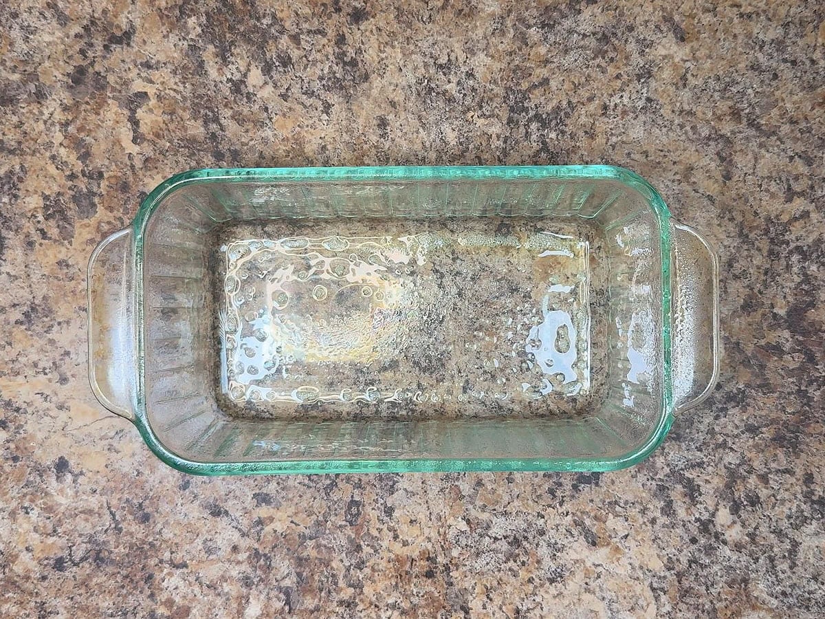 Greasing a 9 x 5 inch loaf pan.