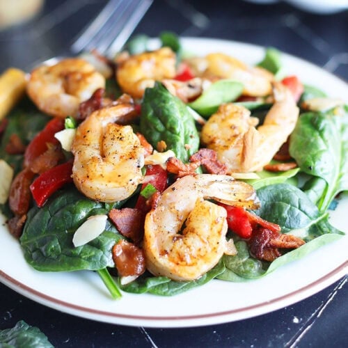 Plated grilled shrimp salad with a fork on the side.