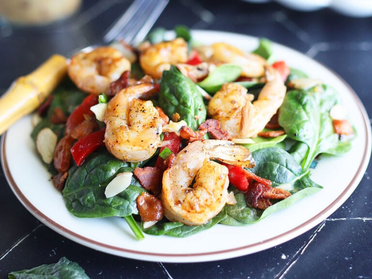 Plated grilled shrimp salad with a fork on the side.