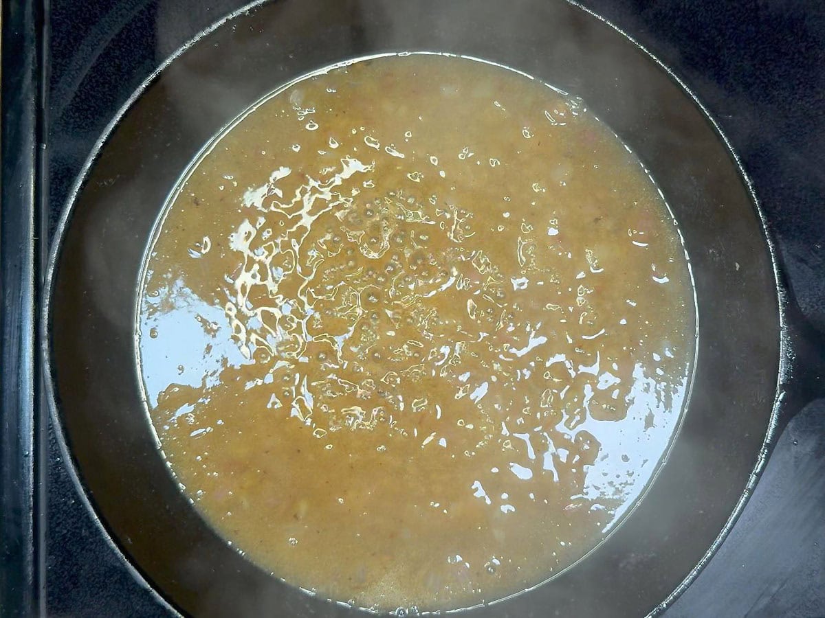 Hot bacon dressing after it has simmered for a few minutes to thicken.