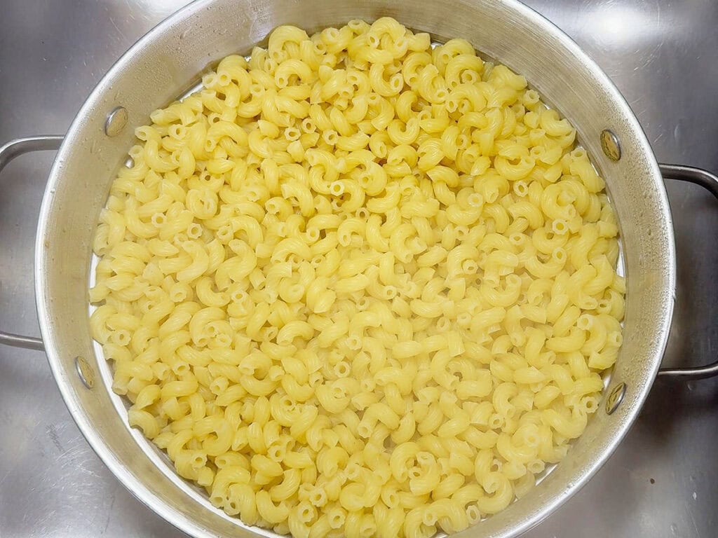 Cooked macaroni draining in a colander.
