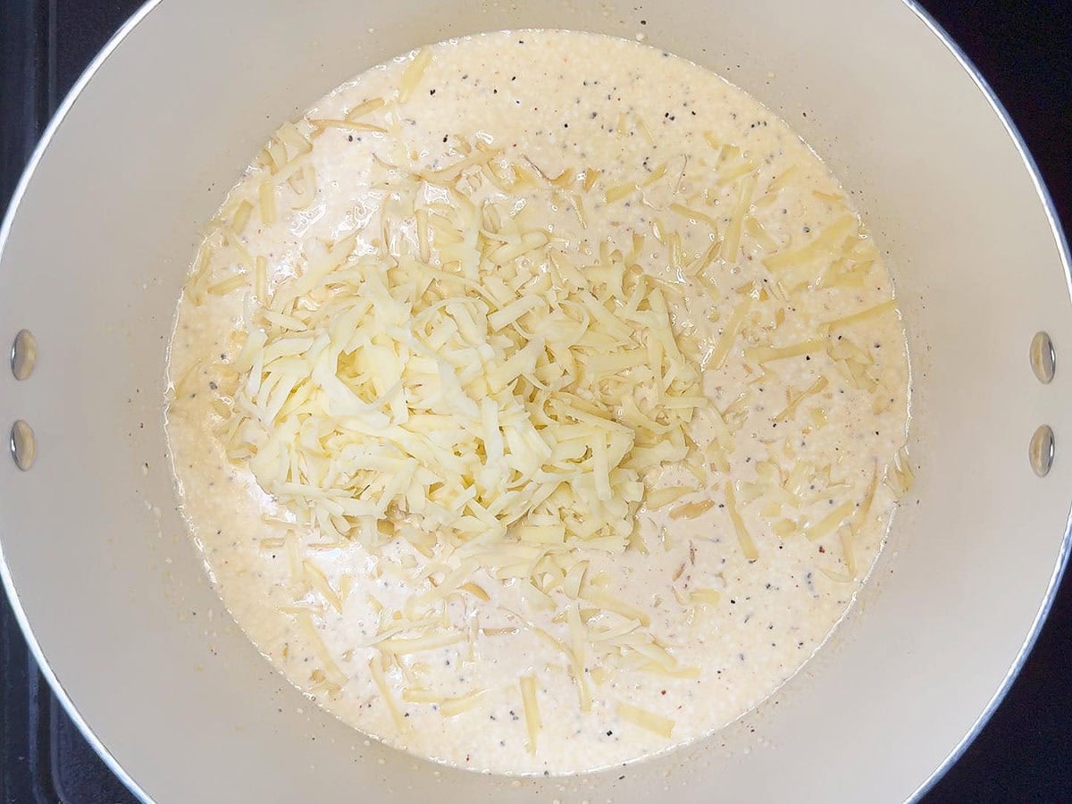 Shredded smoked cheddar added to the melted cream cheese mixture.