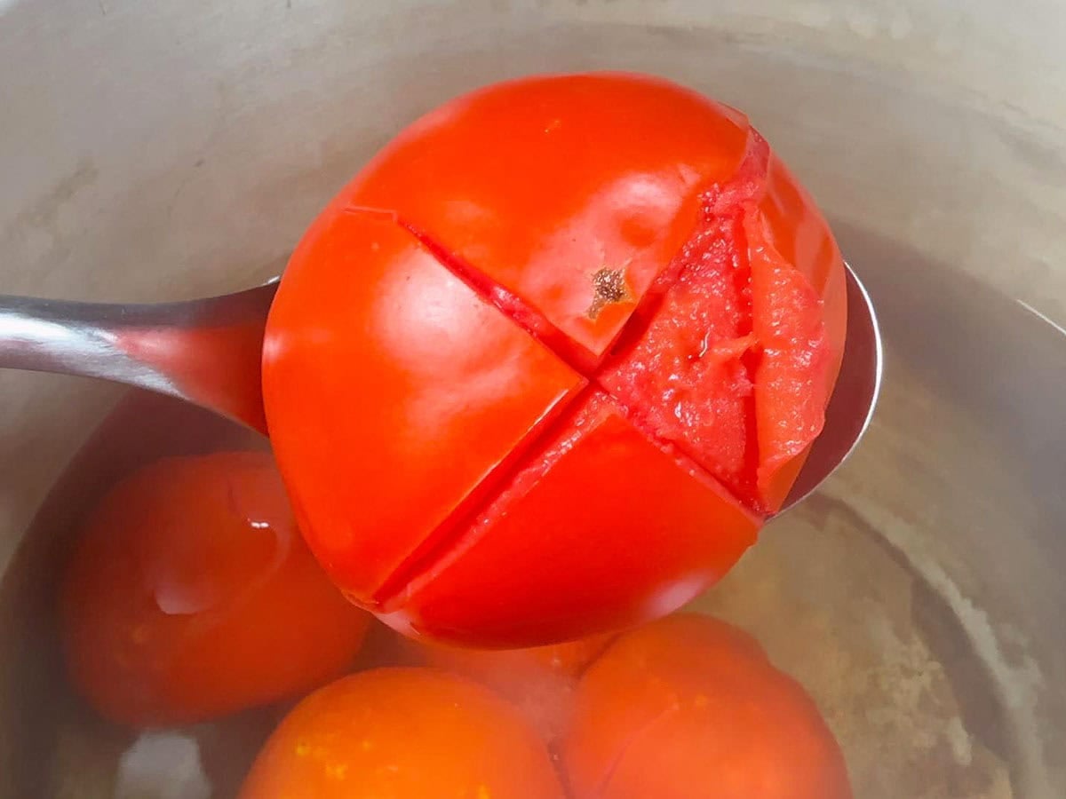 Tomato skin beginning to peel away from the rest of the tomato.