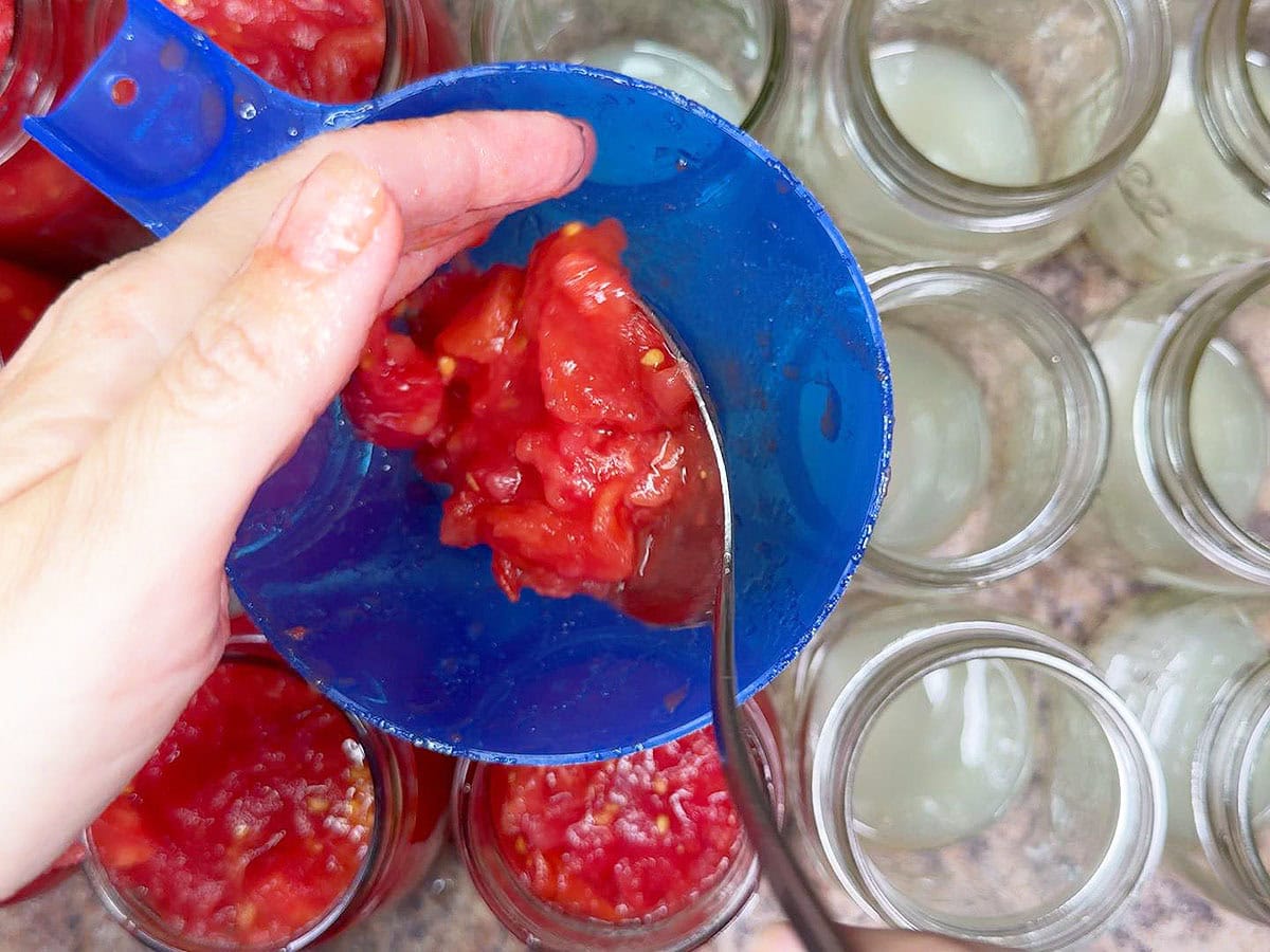 Packing the diced tomatoes into mason jars.