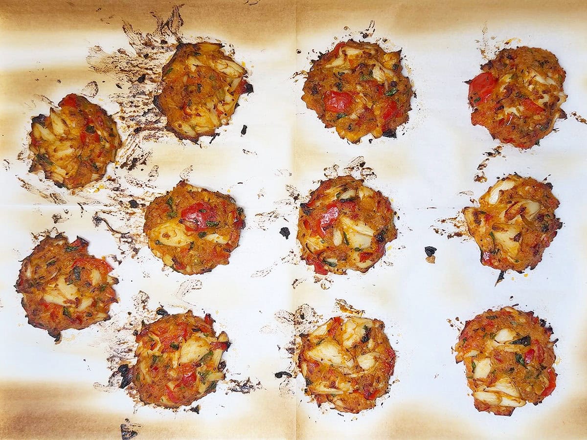 Sheet pan of crab cakes after they have baked in the oven.