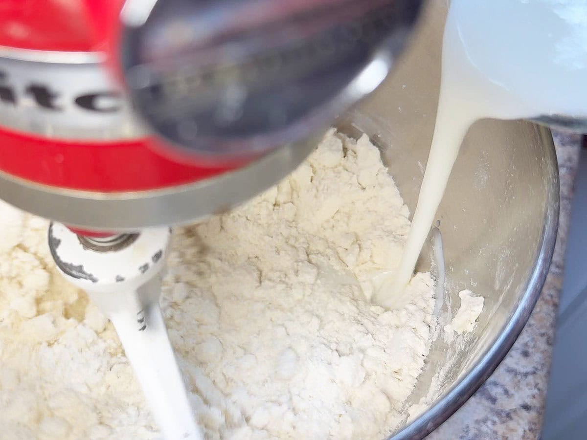 Pouring buttermilk into the biscuit mix.