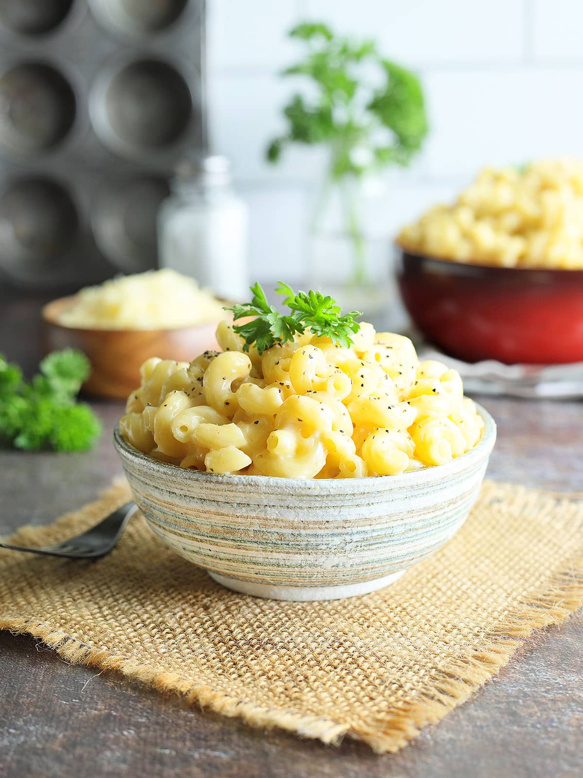 Dish of creamy mac and cheese garnished with pepper and parsley.