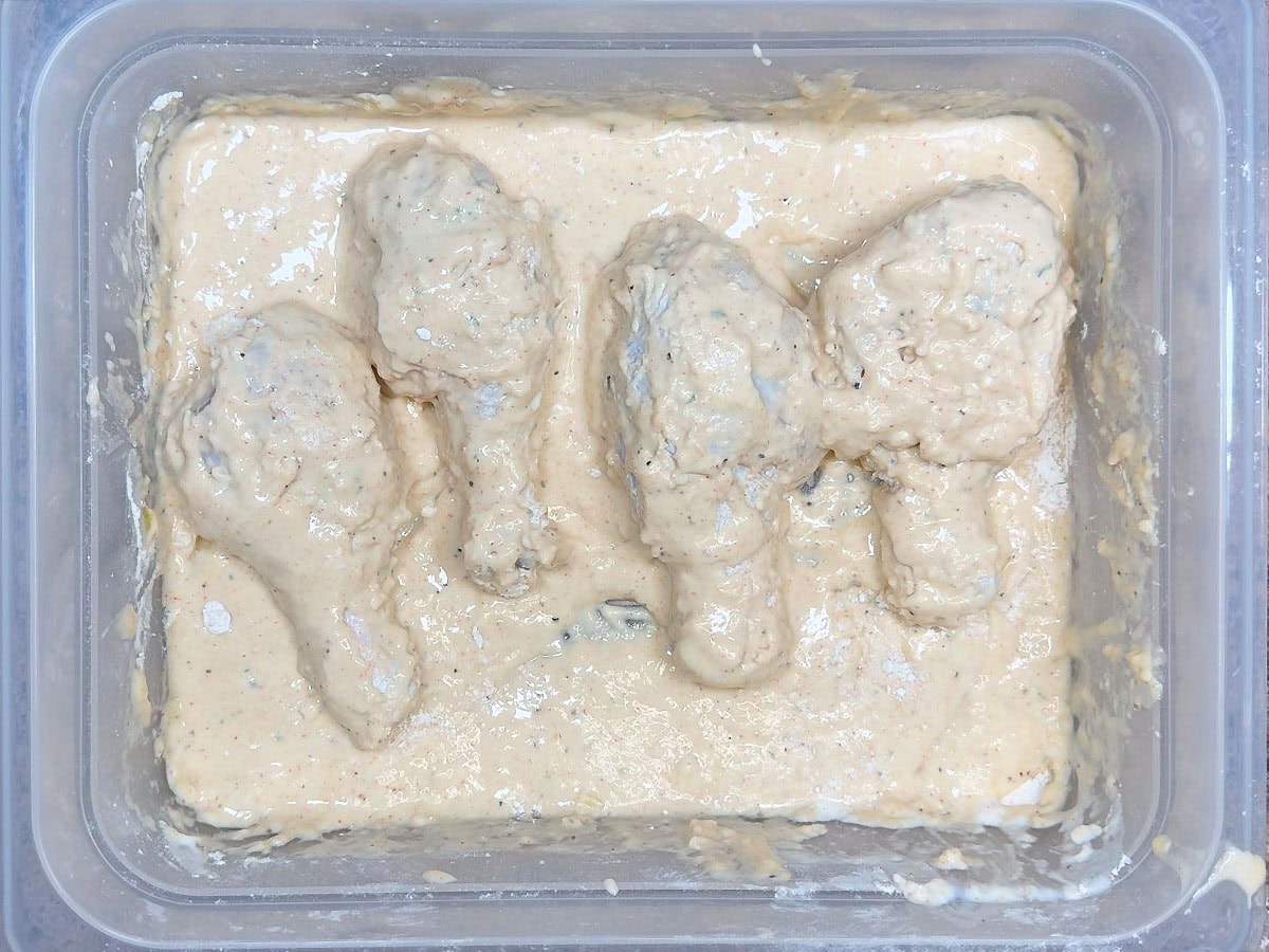 Chicken legs coated in the batter mixture.