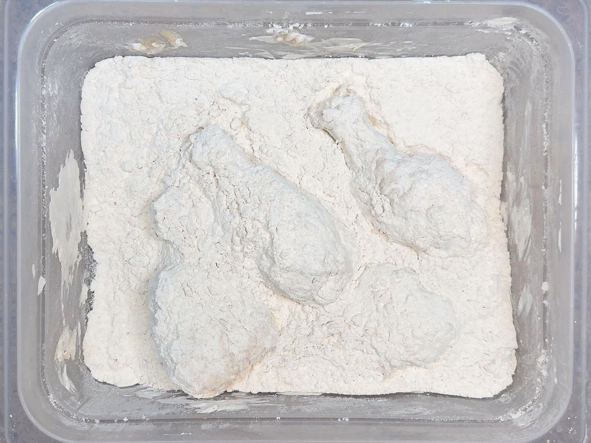 Chicken legs coated in seasoned flour.