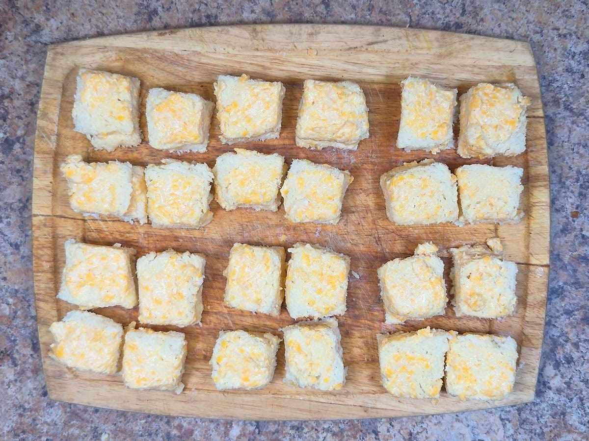 Cheese dreams on a cutting board cut into four pieces.