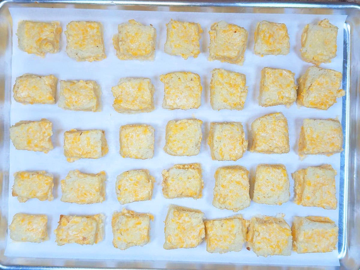 Unbaked cheese dreams on a parchment paper lined baking sheet.