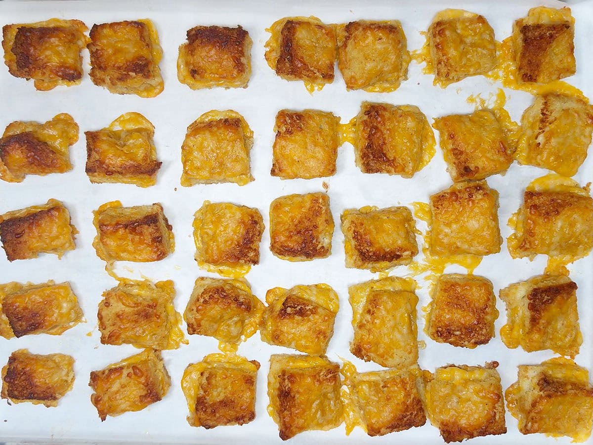 Baked cheese dreams on a parchment paper lined baking sheet.