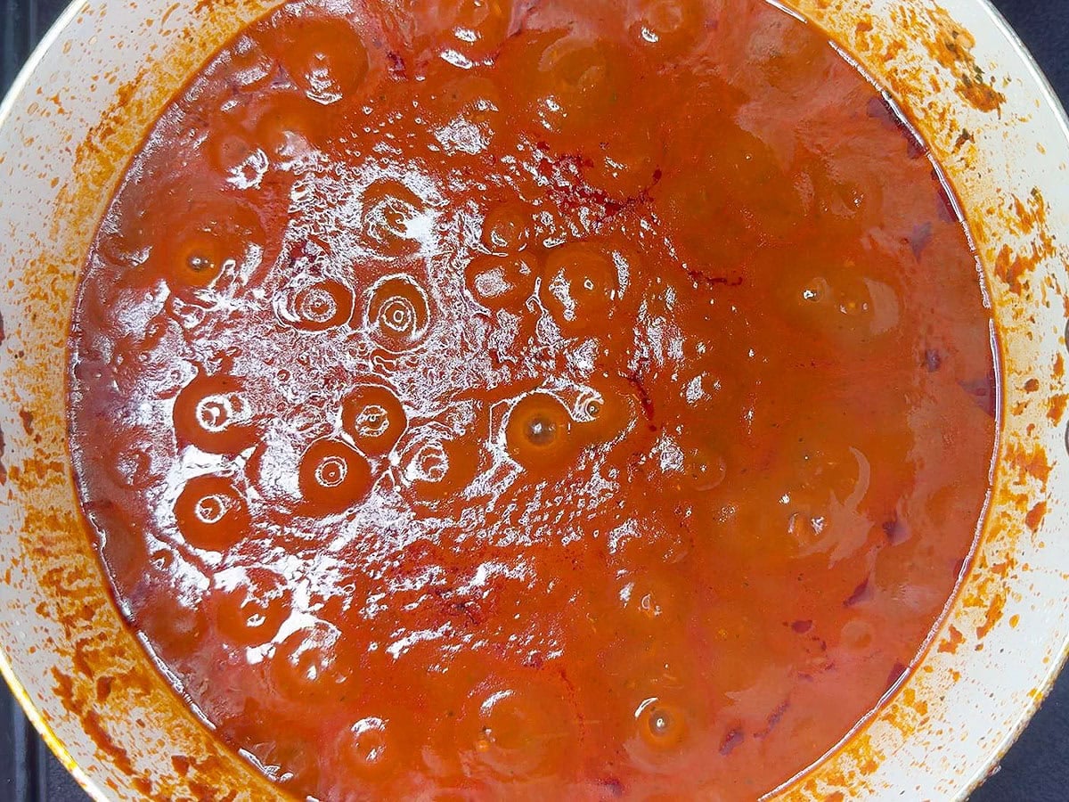 Tomato sauce simmering in a stock pot.