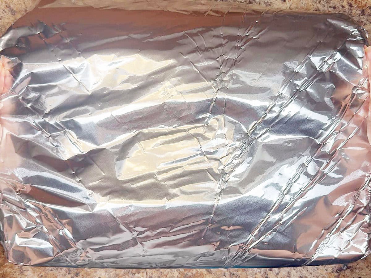 Cover the top of the pan of sausage lasagna with aluminum foil.