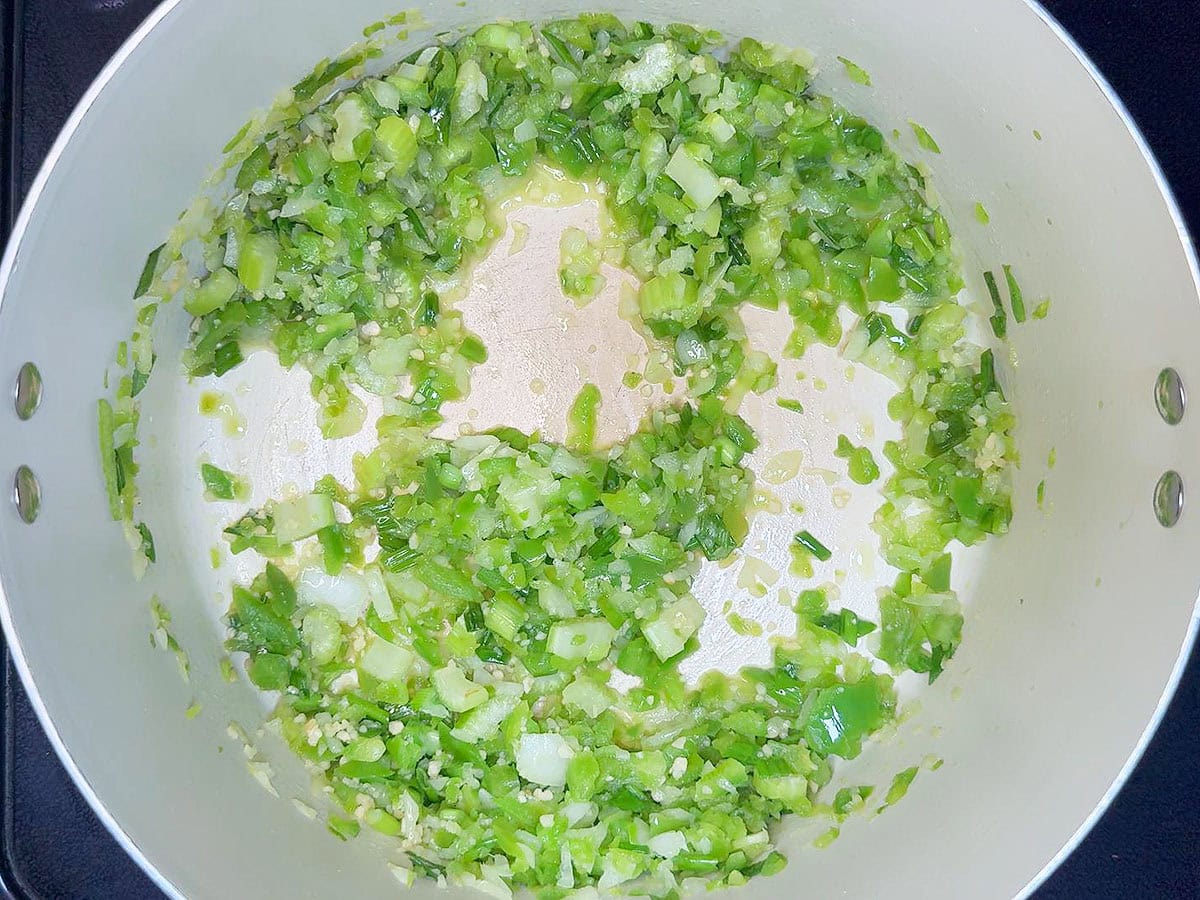Sauteed vegetables and garlic cooked in butter in a large stock pot.