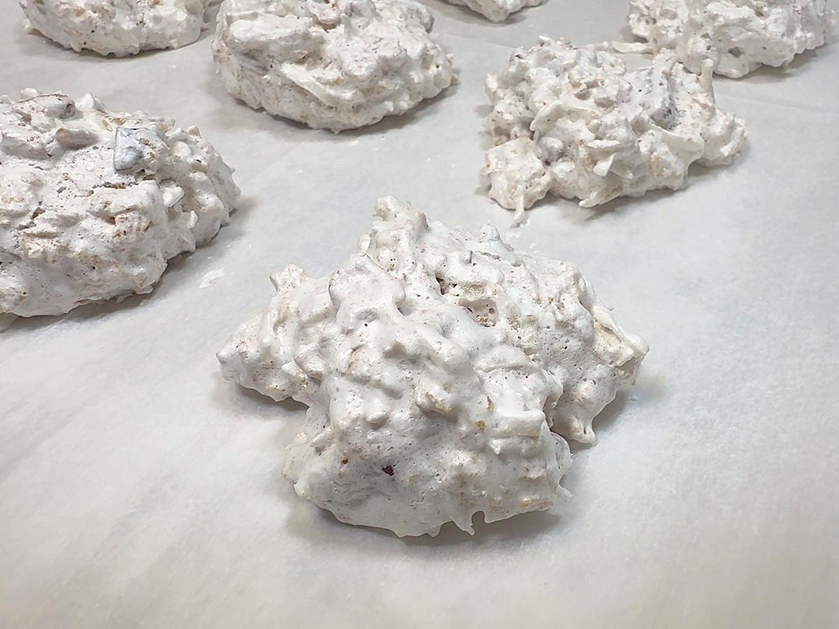 Baked cornflake cookie on a parchment lined baking sheet.
