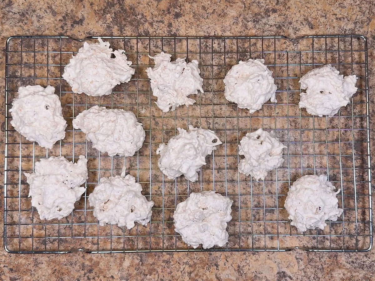 Cornflake cookies cooling on a baking rack.