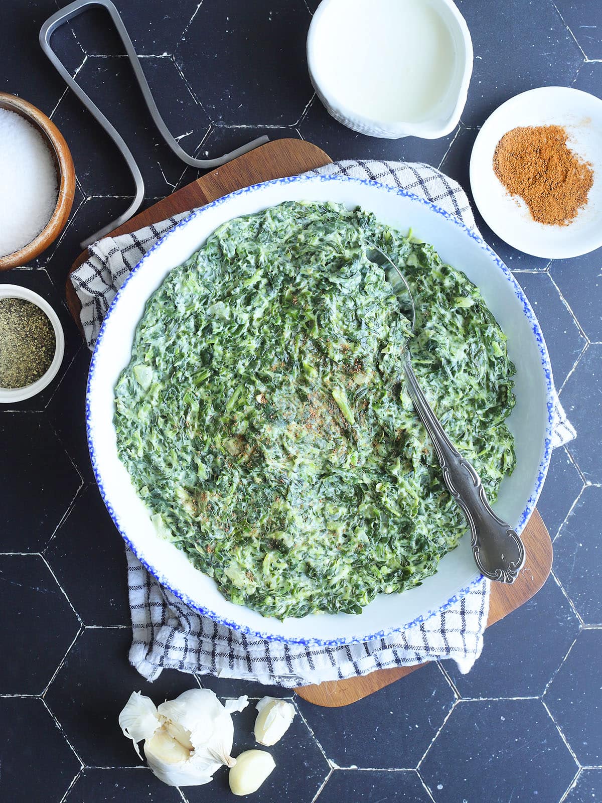 Serving bowl of creamed spinach garnished with nutmeg.
