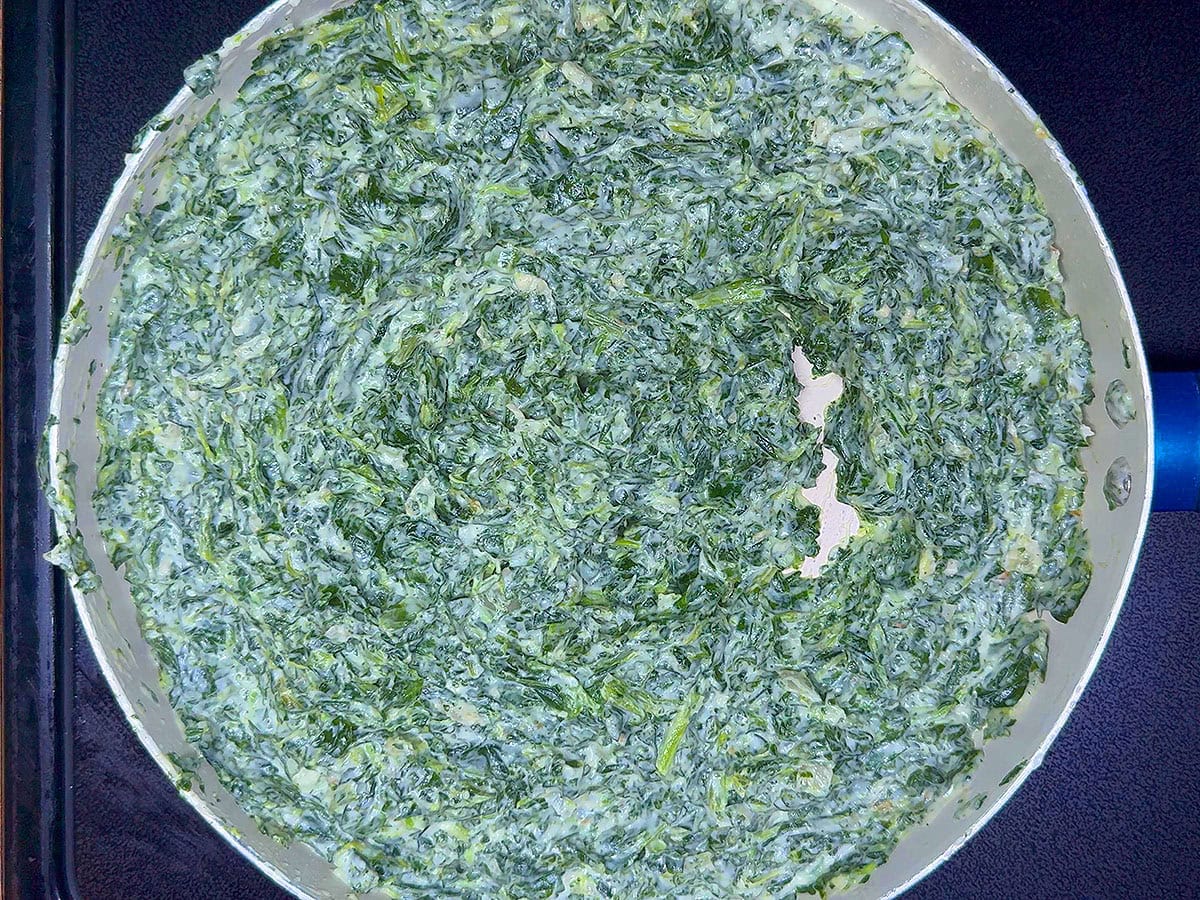 Finished creamed spinach in a saucepan.